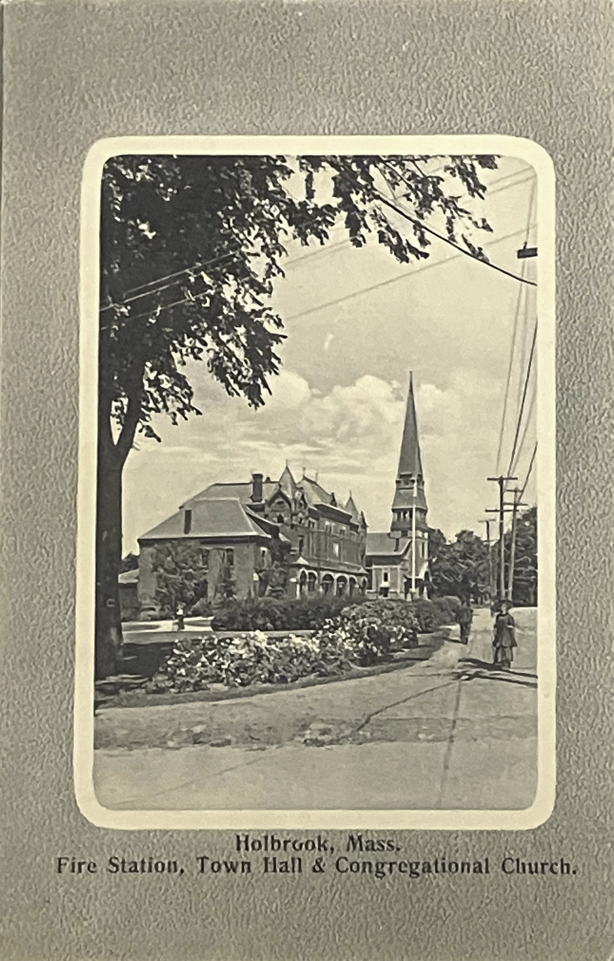 Vintage black and white photo of a town square with a fire station, town hall, and church.