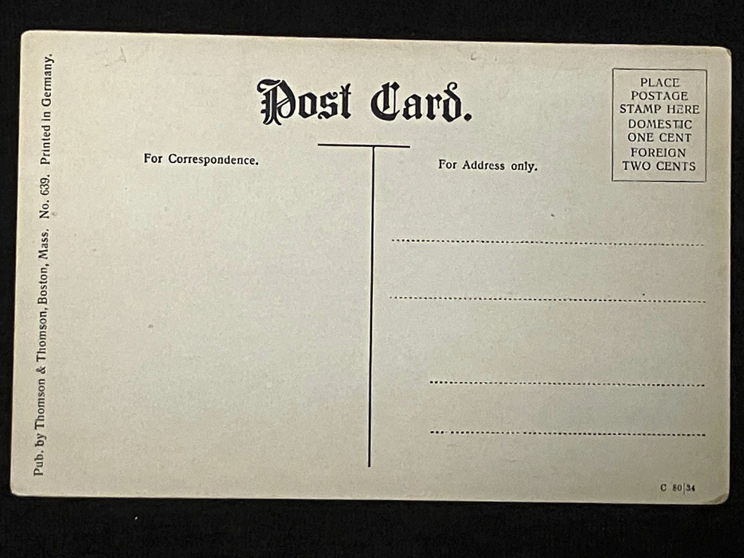 Back of a 1910 postcard with text and design elements on a black background