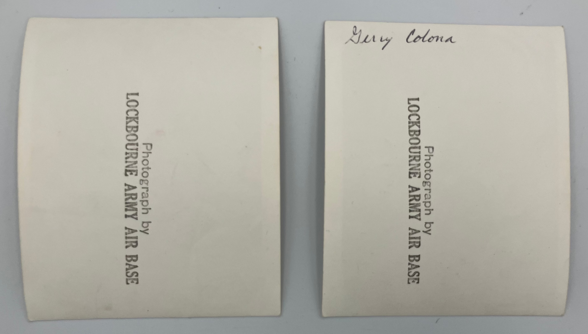 Two cream-colored archival document envelopes or cards with black printed text reading 'Photograph by LOCKBOROUGH ARMY AIR BASE' and a handwritten signature 'Gerry Colonna' on the right one, shown on a light gray background.