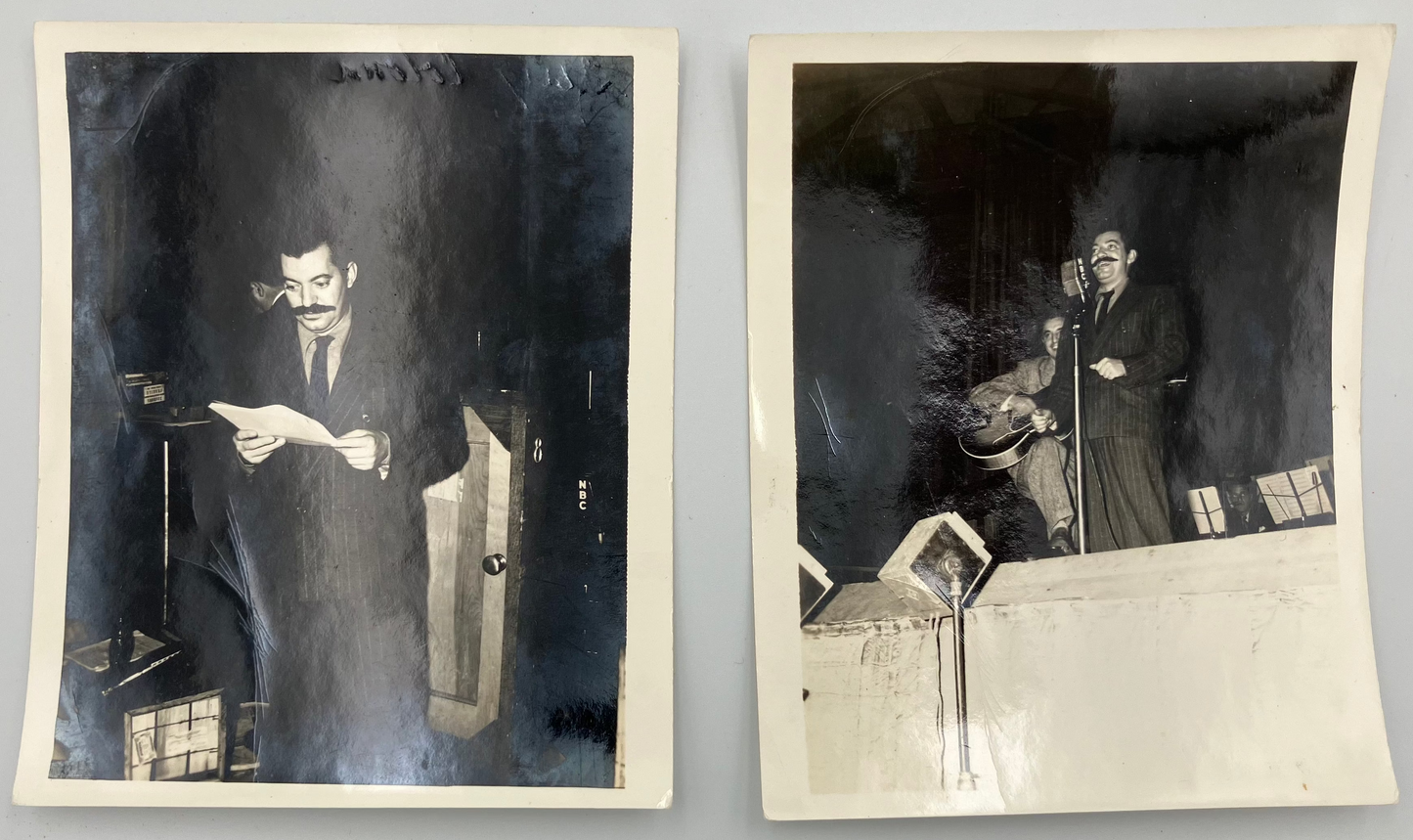 Two vintage black-and-white photographs displayed side by side on a light gray surface. The left photo shows a man in a suit holding papers near a machine, and the right photo shows the same man standing at a microphone on a stage or raised platform.