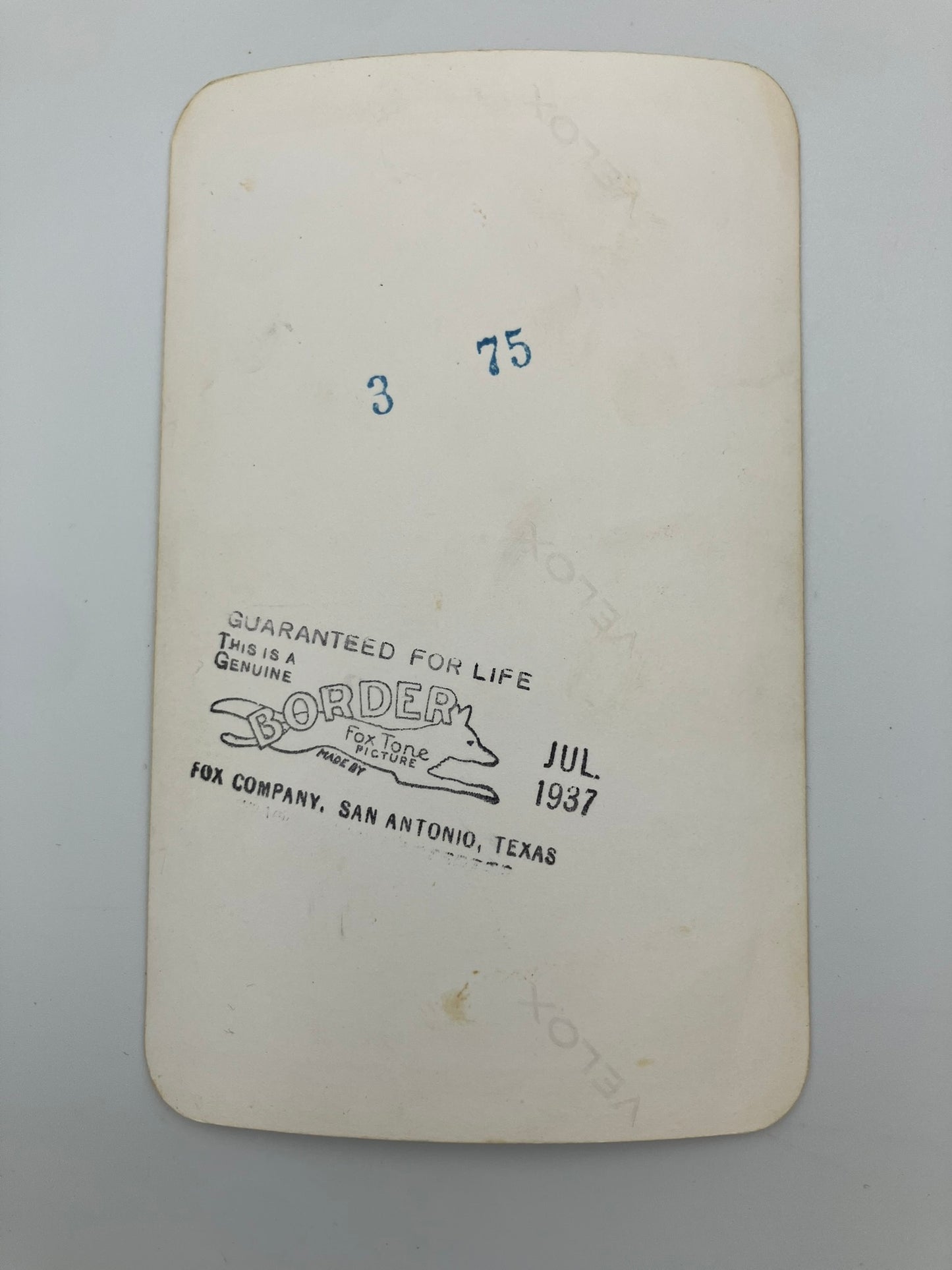 An off-white vintage paper label or card with rounded corners, featuring blue handwritten numbers '3' and '75' and a black printed stamp reading 'GUARANTEED FOR LIFE' with 'BORDER' and 'FOR COMPANY, SAN ANTONIO, TEXAS' near the bottom.