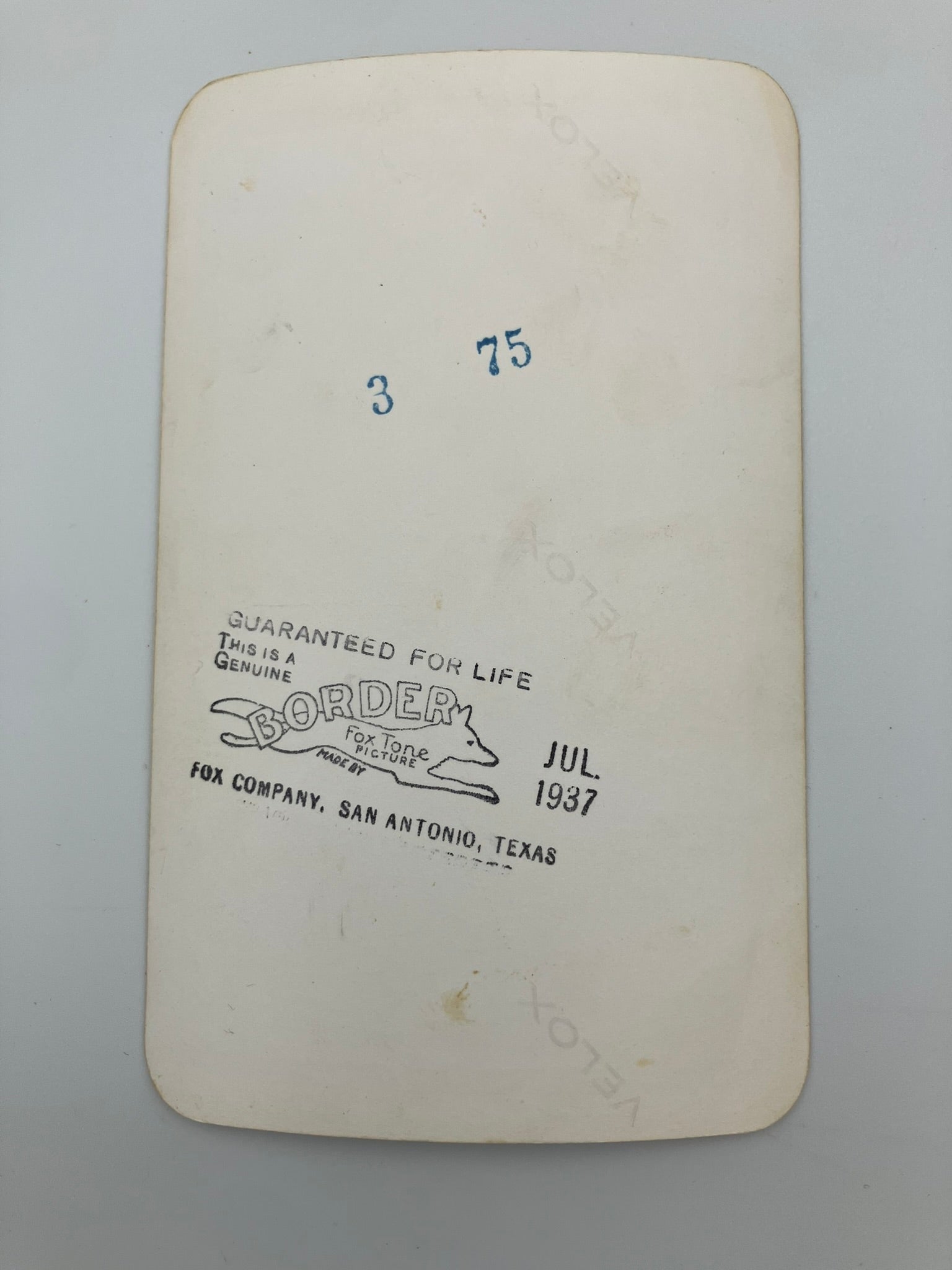 An off-white vintage paper label or card with rounded corners, featuring blue handwritten numbers '3' and '75' and a black printed stamp reading 'GUARANTEED FOR LIFE' with 'BORDER' and 'FOR COMPANY, SAN ANTONIO, TEXAS' near the bottom.