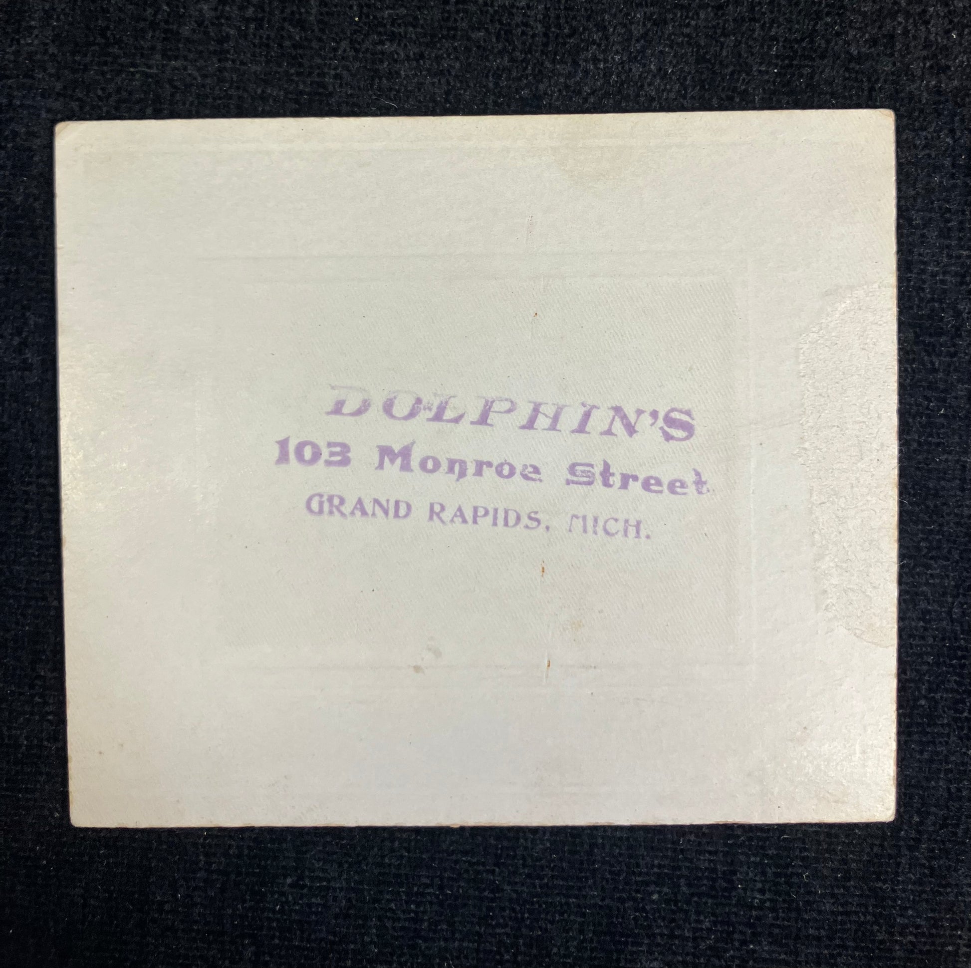 Vintage card with 'Dolphin's' branding and address on a dark background