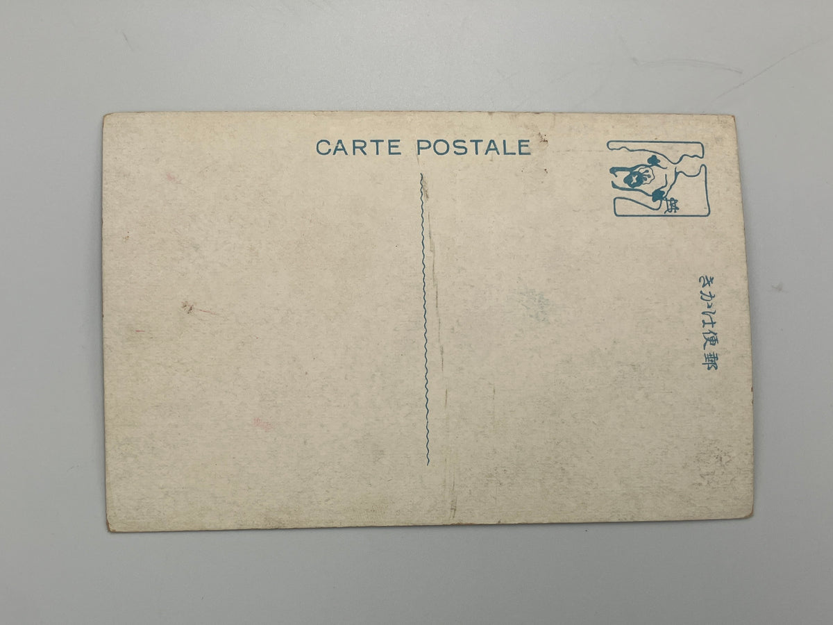 Vintage Japanese postcard back with 'CARTE POSTALE' printed at the top, a blue stamp box in the upper right, and Japanese text on the right side, photographed on a neutral gray background.