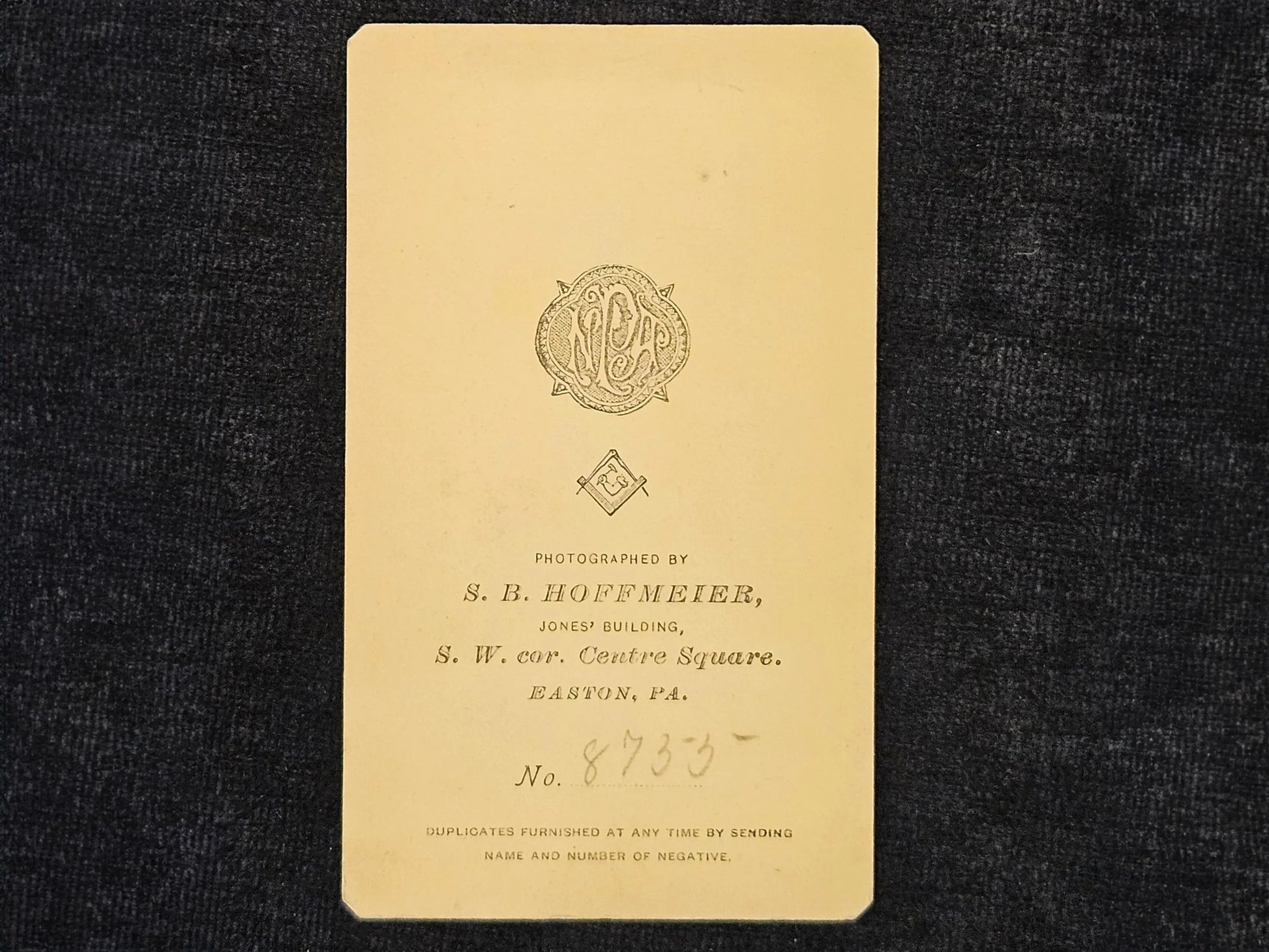 Vintage photograph album page with a logo and text on a dark background