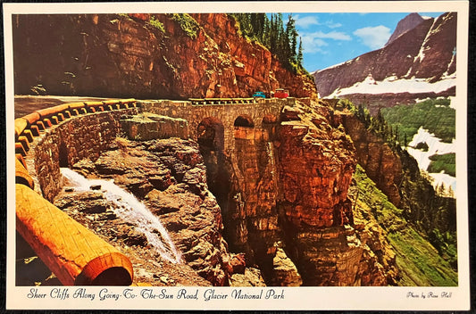 Vintage Postcard:  Glacier National Park, a scenic view of a mountain road with sheer cliffs and snow.
