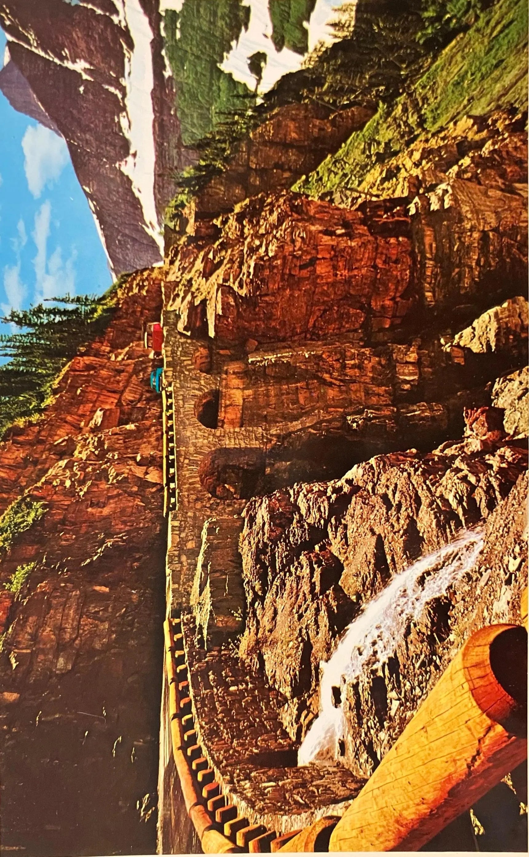 Vintage Postcard:  Glacier National Park, a scenic view of a mountain road with sheer cliffs and snow.
