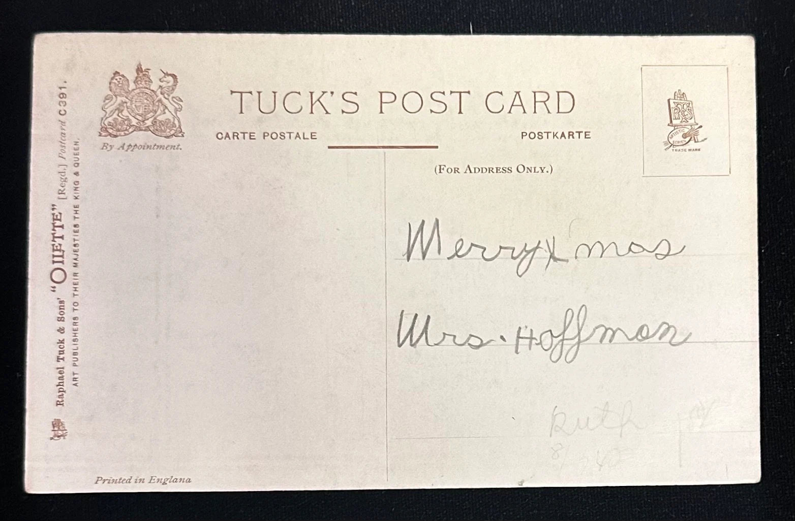 Vintage Tuck's postcard with text and a signature on a black background