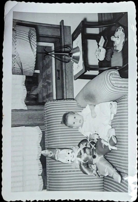 Black and White Photo of Baby and Celluloid faced Clown Doll