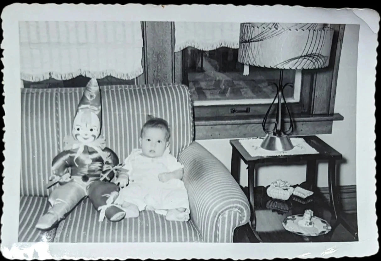 Black and White Photo of Baby and Celluloid faced Clown Doll