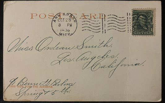 Vintage postcard with postage stamp and handwritten text, featuring a green stamp on a light brown background.