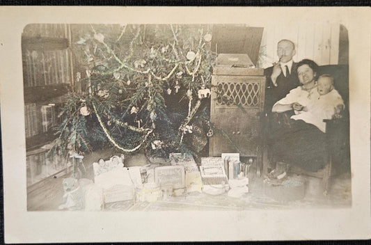 RPPC - Family by Christmas Tree - 1930 Phonograph in Background - Gifts Under Tree for Mother, Father, and Baby - Blown Glass Ornaments on Tree