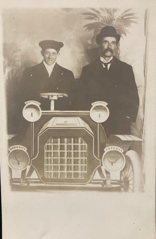 RPPC - Men Posing in a Photographer's Prop Car - One in a Dapper Driving Outfit, the second looking Wealthy and Wise - Likely a Parody Photo
