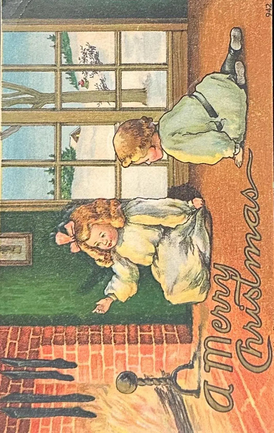 Children by the Fireplace with Stockings - A Merry Christmas - Vintage Postcard