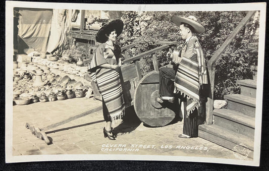 Vintage black and white photo of a couple on a wooden deck with a scenic background in Olvera Street, Los Angeles, Calif.