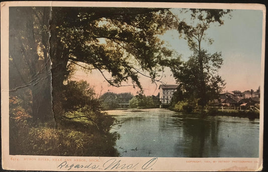 Vintage postcard with reflective water surface with trees and a building in the background of Huron River, Ann Arbor, MI