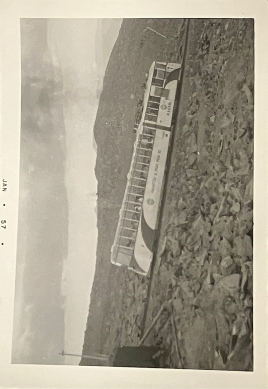 Tram passing over rocky terrain with visible date 'JAN 57'.