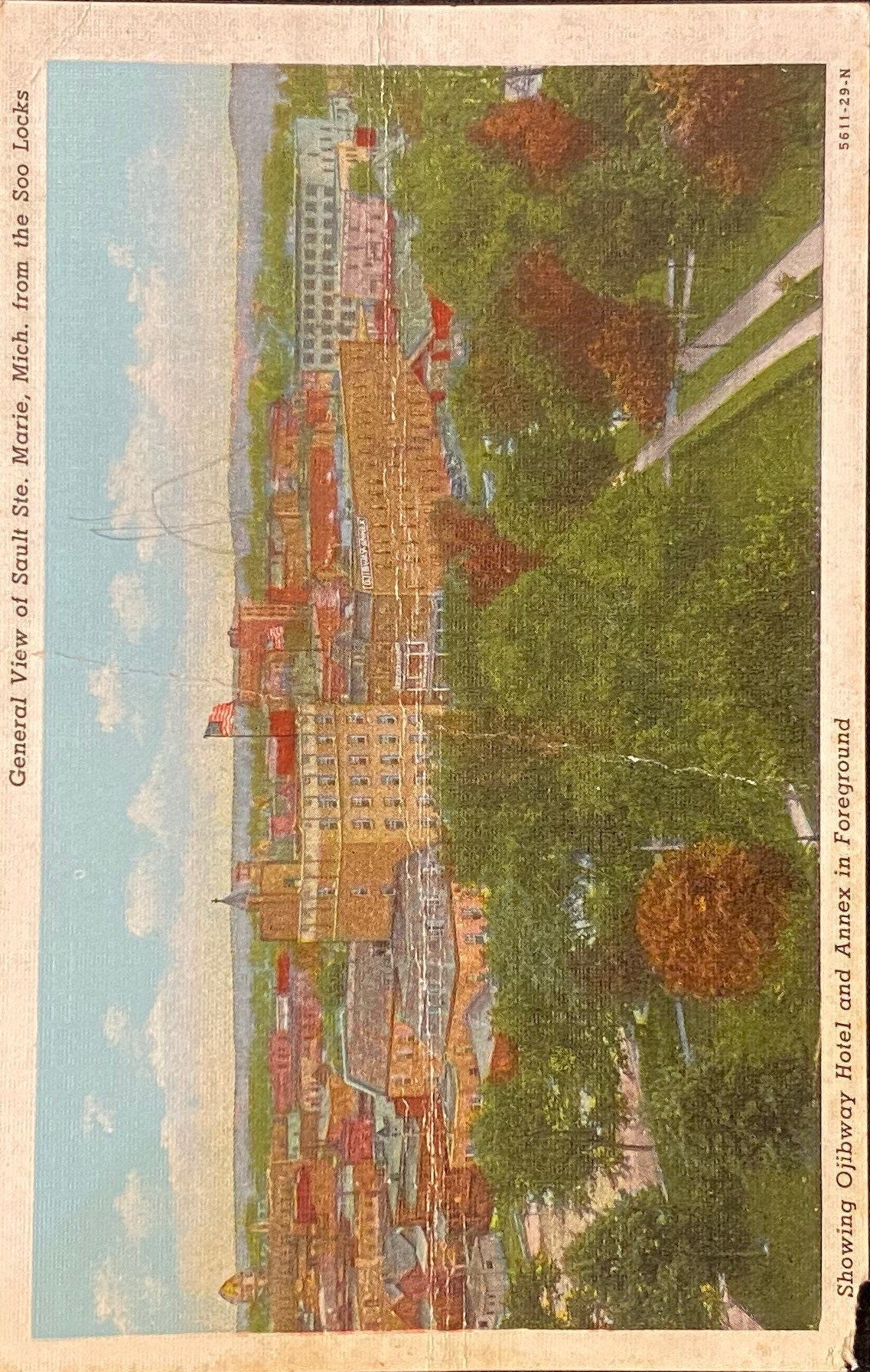 Vintage-style postcard of a Sault Saint Marie cityscape with buildings and greenery.