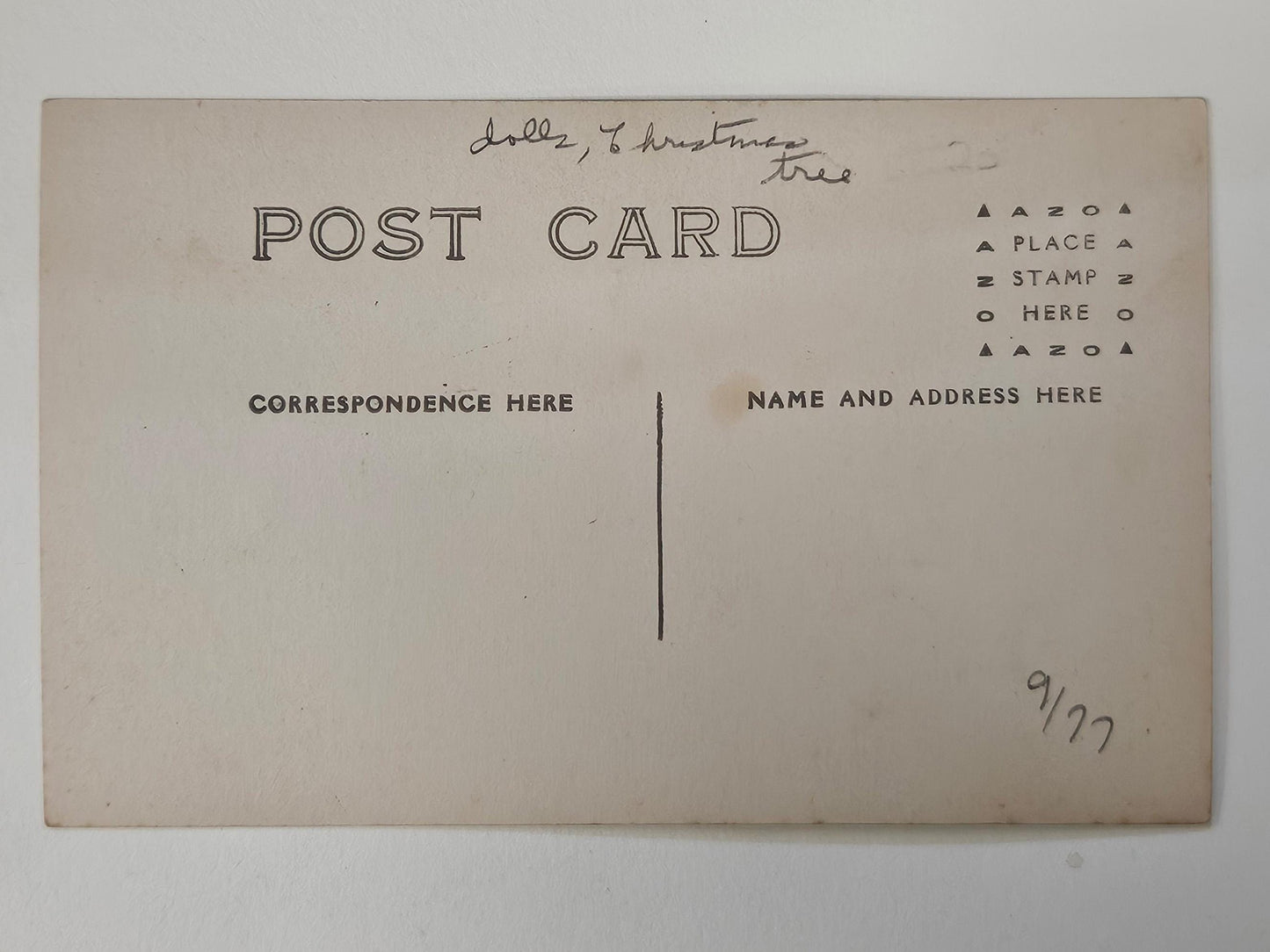 The dolls, the tinsel tree decorations and little girls dresses in this RPPC are like those found in